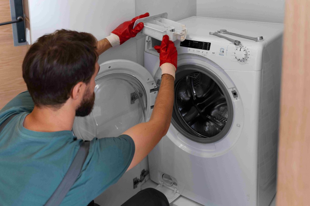 Person fixing washing machine from back panel